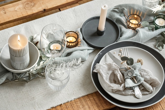 Nahaufnahme Detail einer festlichen Tischdekoration mit einem Satz Besteck, einem Teller und Kerzen in Kerzenhaltern.