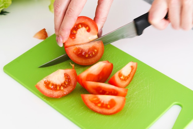 Nahaufnahme, die Tomaten schneidet