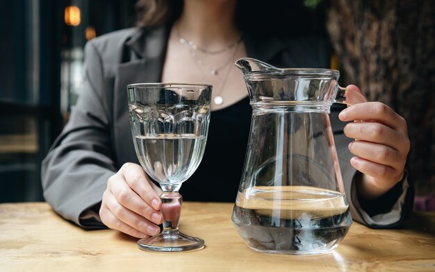 Nahaufnahme eine Frau gießt Wasser in ein Glas in einem Café