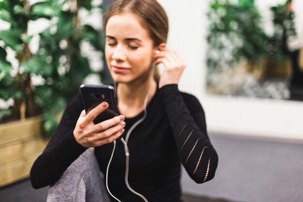 Nahaufnahme einer athletischen Frau, die Musik hört