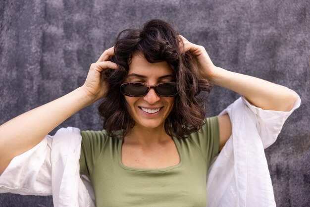 Nahaufnahme einer attraktiven Frau, die mit Sonnenbrille lächelt