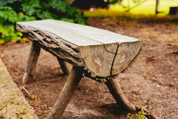 Nahaufnahme einer Bank aus Stämmen im Garten