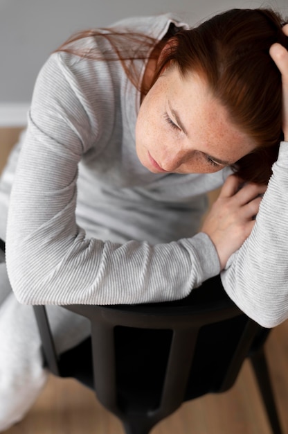 Nahaufnahme einer depressiven Frau, die auf einem Stuhl sitzt