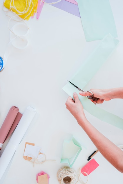 Nahaufnahme einer Frau, die das Kartenpapier mit der Schere schneidet