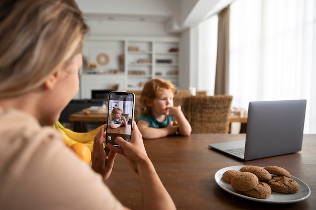 Nahaufnahme einer Frau, die Fotos von Kind macht