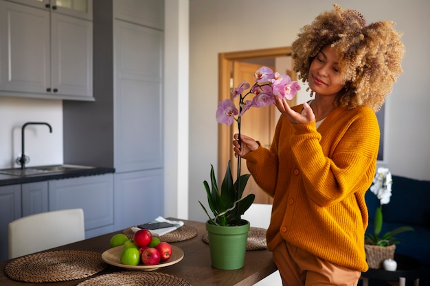 Nahaufnahme einer Frau, die ihr Zuhause mit Orchideen dekoriert