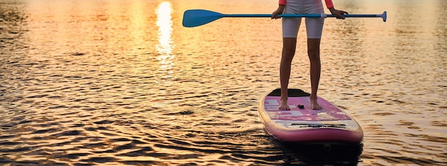 Nahaufnahme einer Frau, die mit Paddel auf einem Sup-Board steht