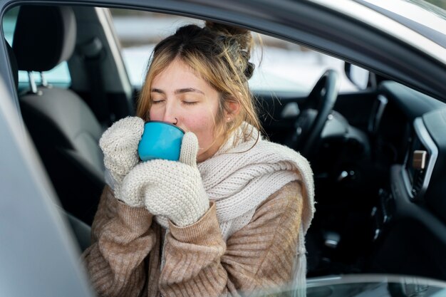 Nahaufnahme einer Frau, die während einer Winterreise ein heißes Getränk genießt
