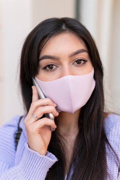 Nahaufnahme einer Frau mit rosa Maske