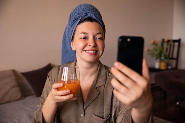 Nahaufnahme einer frischen Frau, die zu Hause ein Selfie mit einem Cocktail macht