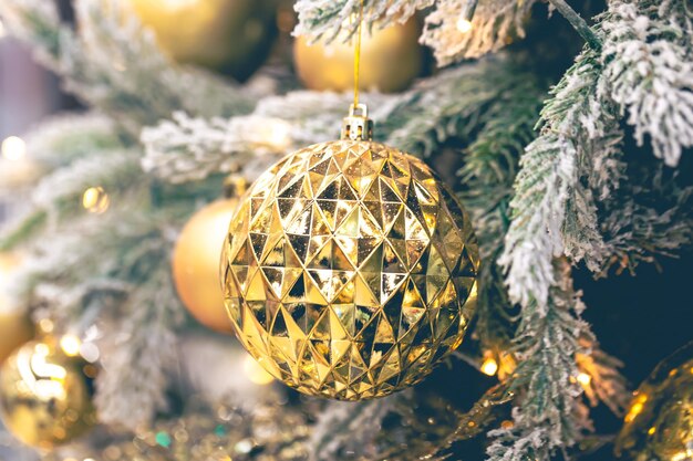 Nahaufnahme einer goldenen Kugel auf einem Weihnachtsbaum in Nahaufnahme