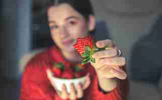 Kostenloses Foto nahaufnahme einer großen appetitlichen erdbeere in den händen einer jungen frau