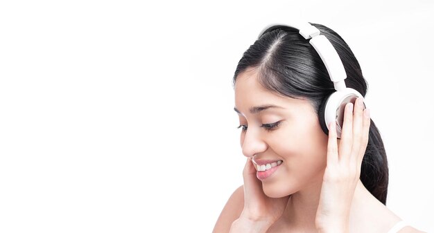 Nahaufnahme einer hispanischen Frau, die mit ihren Kopfhörern Musik hört