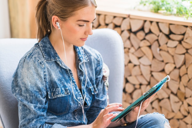 Nahaufnahme einer hübschen Frau, die digitalen Vorsprung hört und verwendet