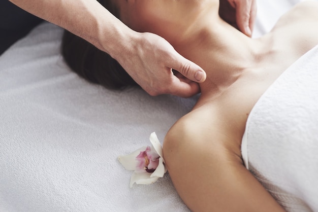 Nahaufnahme einer jungen Frau bekommt eine Massage im Schönheitssalon. Verfahren für Haut und Körper.