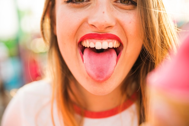 Nahaufnahme einer jungen Frau, die Zunge heraus haftet