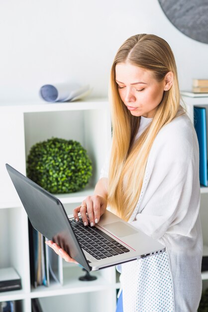 Nahaufnahme einer jungen Geschäftsfrau, die an Laptop arbeitet