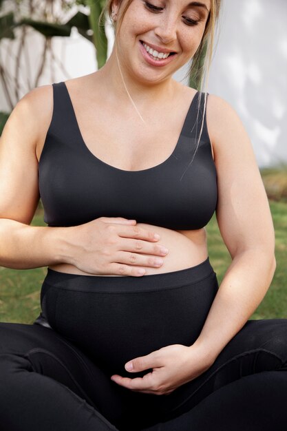 Nahaufnahme einer jungen schwangeren Frau beim Yoga