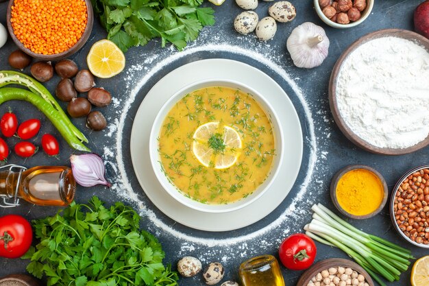 Nahaufnahme einer köstlichen Suppe, serviert mit Zitrone und Grün in einer weißen Schüssel und Mehl Tomatenöl Flasche Mehl Grün bündelt Eier auf dunklem