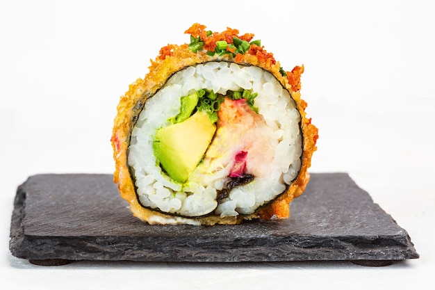 Nahaufnahme einer köstlichen Sushi-Rolle mit Gewürzen auf weißem Hintergrund