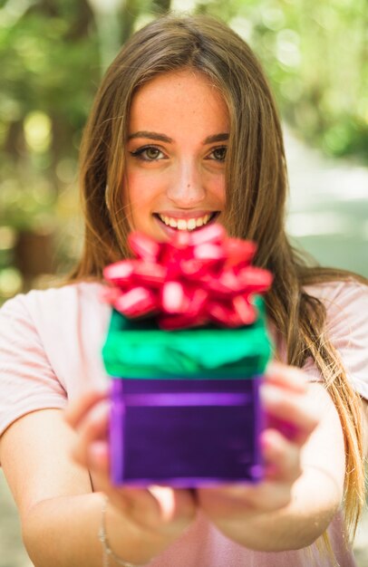 Nahaufnahme einer lächelnden Hand der Frau, die Valentinsgrußgeschenk hält