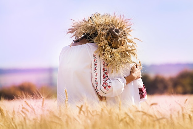 Nahaufnahme einer Mutter und einer Tochter, die zusammen auf einem Weizenfeld sitzen