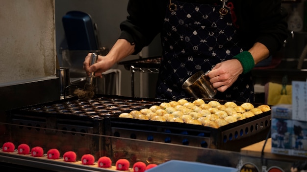 Nahaufnahme einer Person, die japanisches Straßenessen kocht