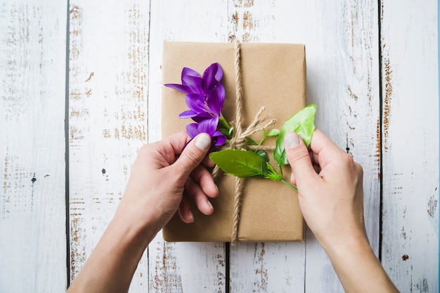 Nahaufnahme einer Person, welche die Blumen auf dem gepackten Paket berührt