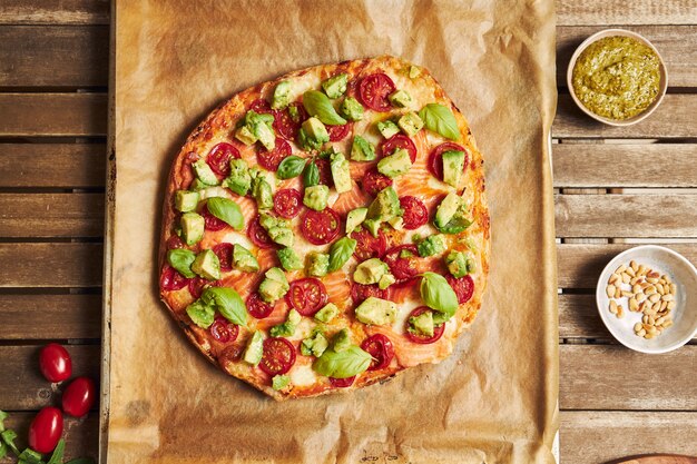 Nahaufnahme einer Pizza mit Gemüse auf Holztisch