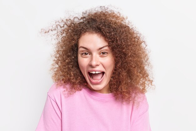 Nahaufnahme einer positiven jungen europäischen Frau, die glücklich aussieht, sagt wow, als sie etwas Unglaubliches sieht, das in einem lässigen Pullover isoliert über einer weißen Wand gekleidet ist, hat Spaß. Emotionen Konzept