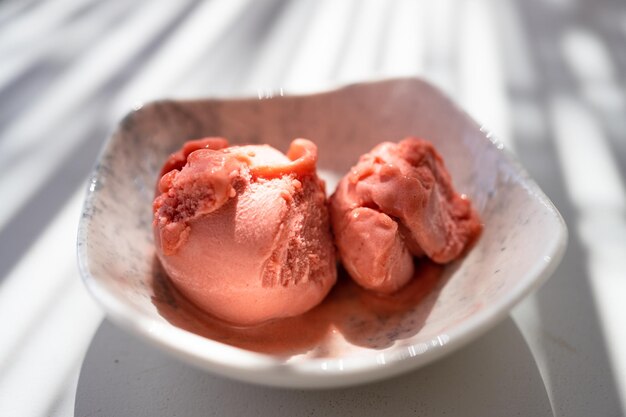 Nahaufnahme einer Schüssel mit Kugeln rosa Eis