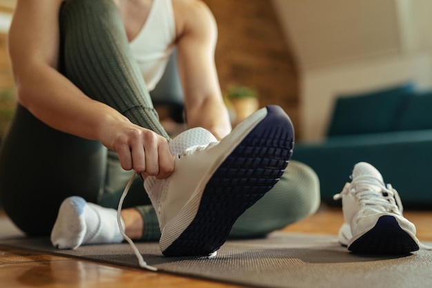 Nahaufnahme einer sportlichen Frau, die Turnschuhe anzieht.