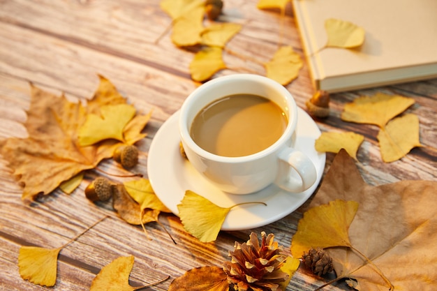 Nahaufnahme einer Tasse Kaffee und Herbstlaub