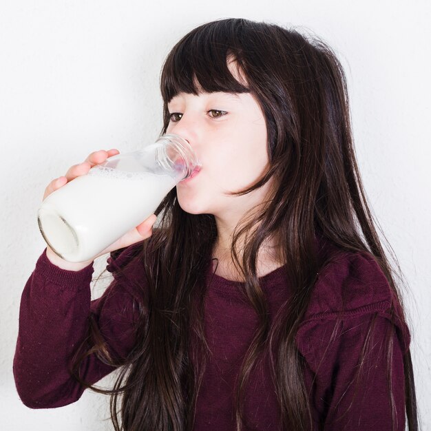 Nahaufnahme einer Trinkmilch des netten Mädchens von der Flasche