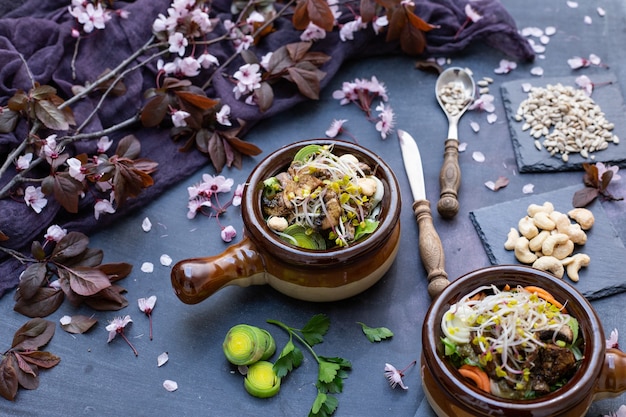 Nahaufnahme einer veganen Mahlzeit mit Pilzen, Zwiebeln, Karotten und Lauch