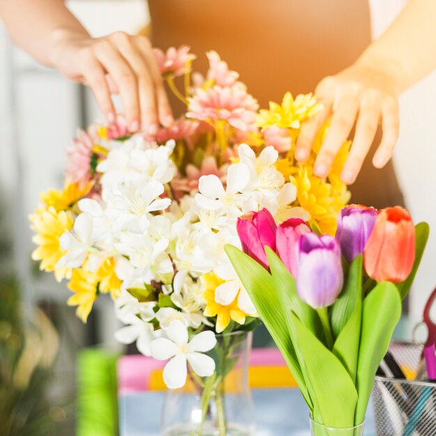 Nahaufnahme einer weiblichen Blumenhändlerhand, die Blumen berührt