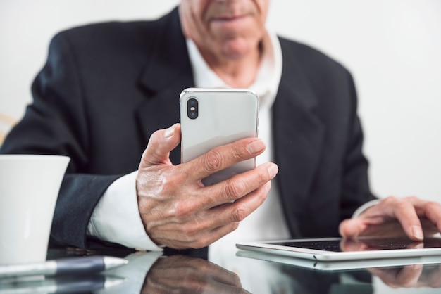 Kostenloses Foto nahaufnahme eines älteren mannes, der in der hand intelligentes telefon hält