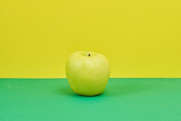 Nahaufnahme eines Apfels auf grünem und gelbem Hintergrund