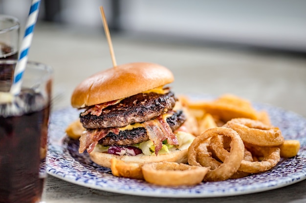 Kostenloses Foto nahaufnahme eines appetitlichen burgers mit zwiebelringen