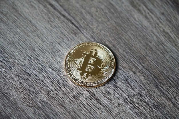 Nahaufnahme eines Bitcoin auf einem Holztisch