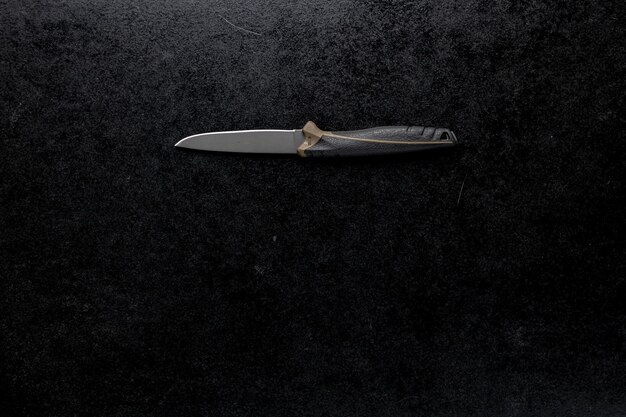 Nahaufnahme eines festen scharfen Messers auf einem schwarzen Tisch