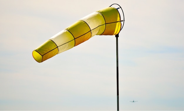 Kostenloses Foto nahaufnahme eines gelben und weißen windsacks, der bei tageslicht in der luft schwebt
