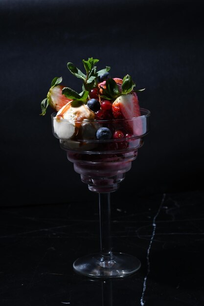 Nahaufnahme eines Glases Schokoladendessert mit verschiedenen Beeren und Früchten