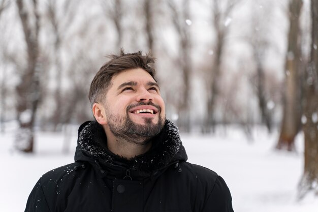 Nahaufnahme eines glücklichen Erwachsenen, der im Schnee spielt