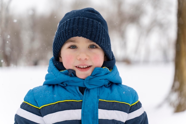 Nahaufnahme eines glücklichen Kindes, das im Schnee spielt