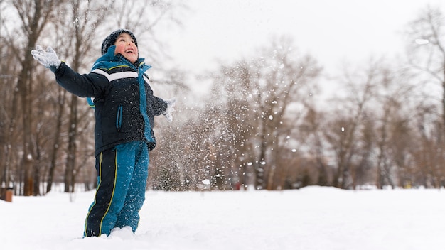 Nahaufnahme eines glücklichen Kindes, das im Schnee spielt