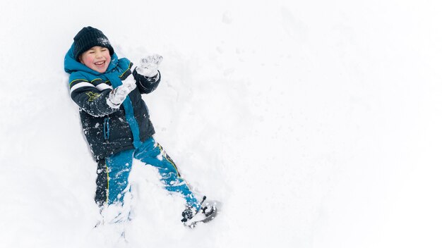 Nahaufnahme eines glücklichen Kindes, das im Schnee spielt