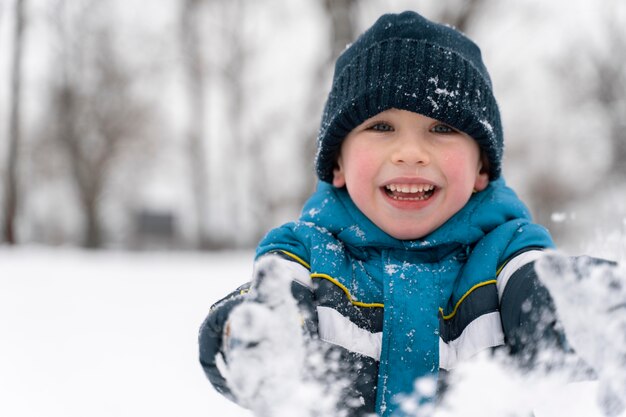 Nahaufnahme eines glücklichen Kindes, das im Schnee spielt