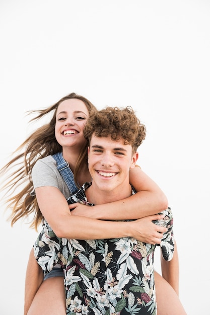 Nahaufnahme eines glücklichen Mannes, der piggyback seiner Freundin auf weißem Hintergrund gibt