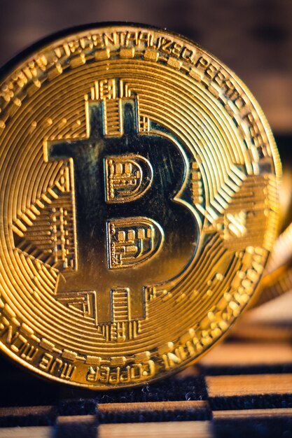 Nahaufnahme eines goldenen Bitcoins auf einem verschwommenen Hintergrund